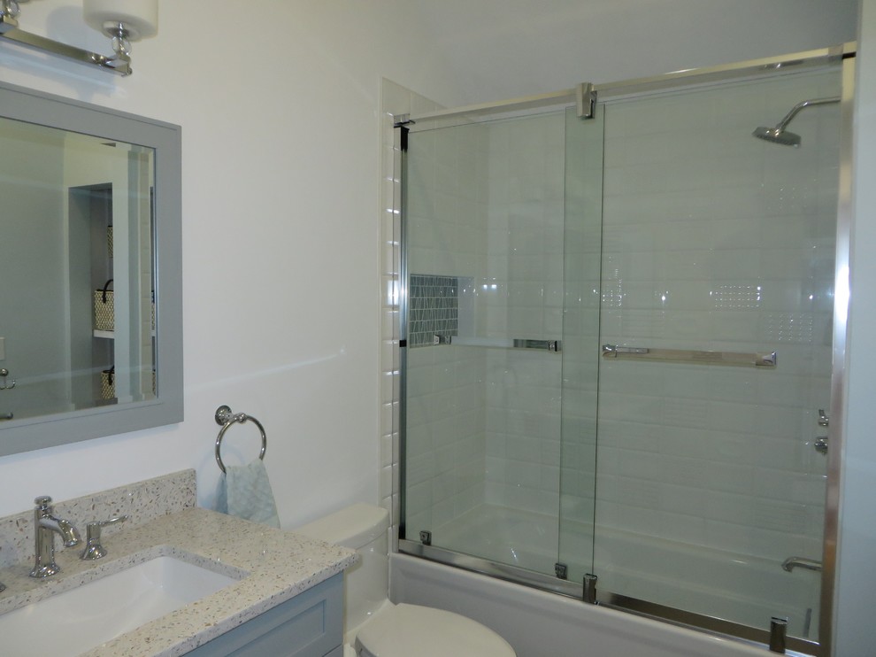 Photo of a medium sized traditional family bathroom in Boston with recessed-panel cabinets, green cabinets, an alcove bath, a shower/bath combination, a one-piece toilet, white tiles, ceramic tiles, green walls, a submerged sink, recycled glass worktops, a sliding door and multi-coloured worktops.