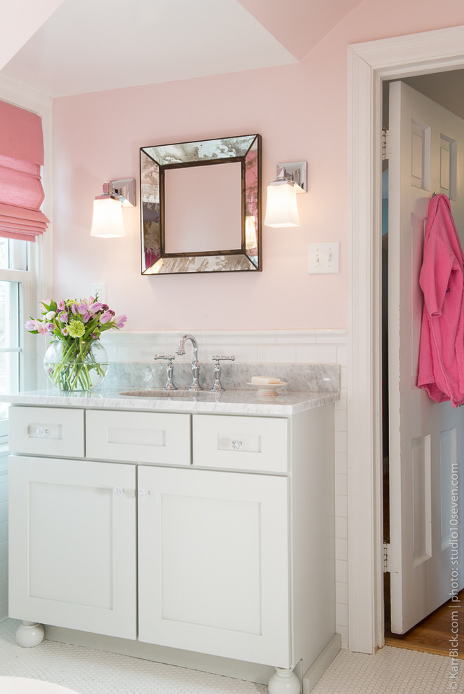 Cette photo montre une douche en alcôve chic de taille moyenne pour enfant avec un placard avec porte à panneau encastré, des portes de placard blanches, une baignoire en alcôve, WC séparés, un carrelage blanc, un carrelage métro, un mur rose, un sol en carrelage de céramique, un lavabo encastré et un plan de toilette en marbre.