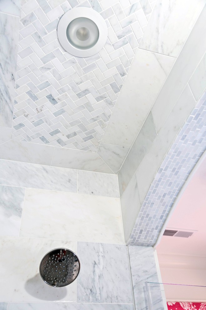 Klassisk inredning av ett litet badrum, med ett undermonterad handfat, luckor med infälld panel, vita skåp, marmorbänkskiva, ett badkar i en alkov, en dusch/badkar-kombination, en toalettstol med separat cisternkåpa, vit kakel, vita väggar och marmorgolv