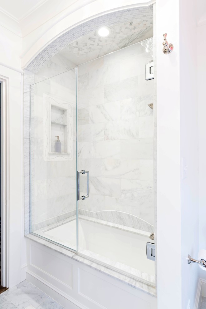 Exempel på ett litet klassiskt badrum för barn, med ett undermonterad handfat, luckor med infälld panel, vita skåp, marmorbänkskiva, ett badkar i en alkov, en dusch/badkar-kombination, en toalettstol med separat cisternkåpa, vit kakel, stenhäll, vita väggar och marmorgolv