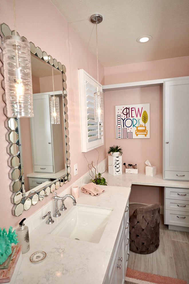 Example of a mid-sized beach style kids' gray tile and porcelain tile porcelain tile and gray floor alcove shower design in San Diego with recessed-panel cabinets, gray cabinets, a two-piece toilet, pink walls, an undermount sink, quartz countertops, a hinged shower door and white countertops