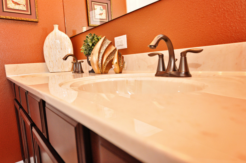 Modelo de cuarto de baño clásico renovado pequeño con armarios con paneles empotrados, puertas de armario de madera en tonos medios, parades naranjas, aseo y ducha, encimera de laminado y lavabo integrado