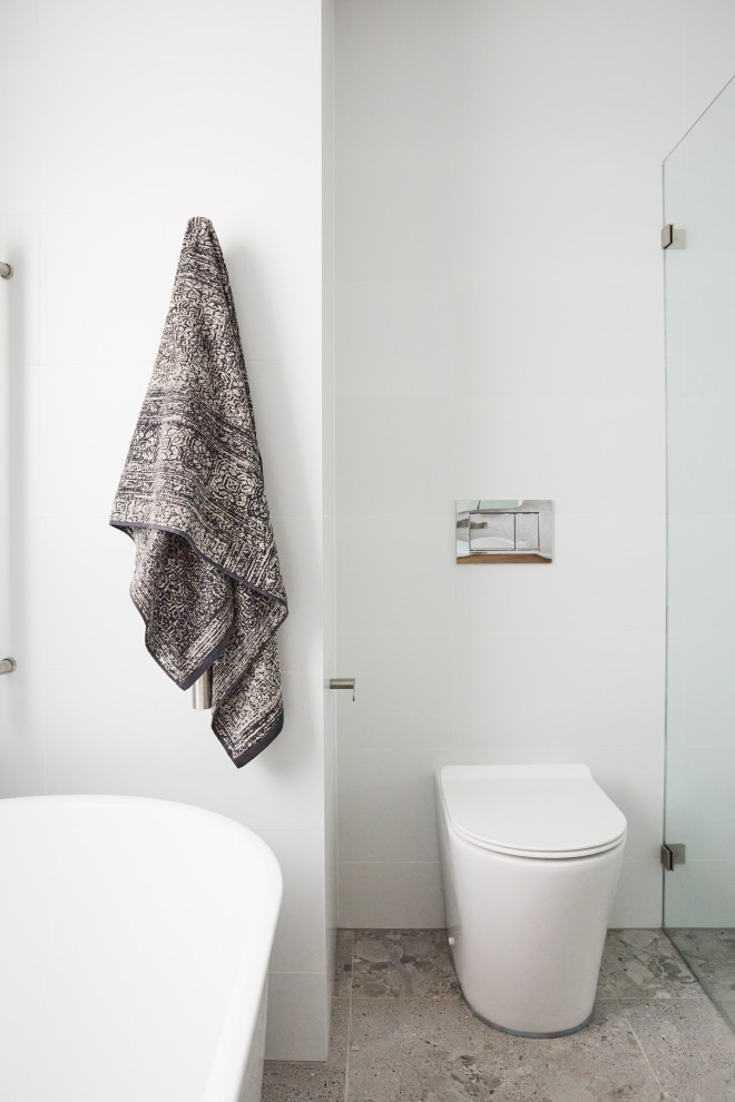 Diseño de cuarto de baño nórdico con sanitario de una pieza, baldosas y/o azulejos blancos, baldosas y/o azulejos de cerámica, suelo de baldosas de cerámica y suelo gris