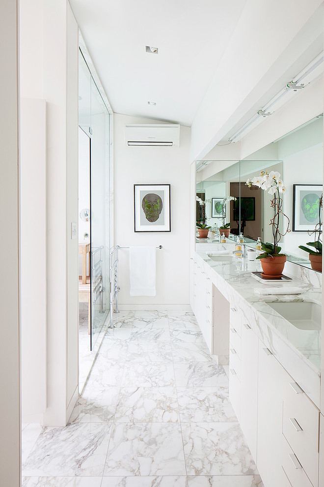 Cette photo montre une salle de bain rétro avec un placard à porte plane, des portes de placard blanches et un mur blanc.