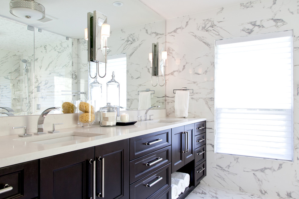 Inspiration for a large transitional master white tile and porcelain tile porcelain tile double shower remodel in Tampa with recessed-panel cabinets, dark wood cabinets, a one-piece toilet, gray walls, an undermount sink and quartzite countertops