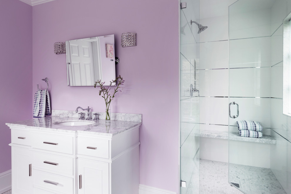 Пример оригинального дизайна: детская ванная комната среднего размера в стиле неоклассика (современная классика) с белыми фасадами, отдельно стоящей ванной, раздельным унитазом, белой плиткой, мраморной плиткой, розовыми стенами, полом из мозаичной плитки, врезной раковиной, мраморной столешницей, белым полом, душем с распашными дверями и душем в нише