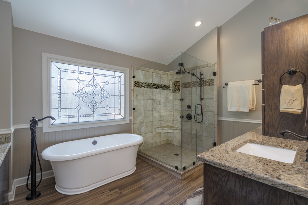 Inspiration for a large rustic master beige tile and porcelain tile medium tone wood floor and brown floor bathroom remodel in Nashville with dark wood cabinets, beige walls, granite countertops, a hinged shower door, shaker cabinets, a two-piece toilet and an undermount sink