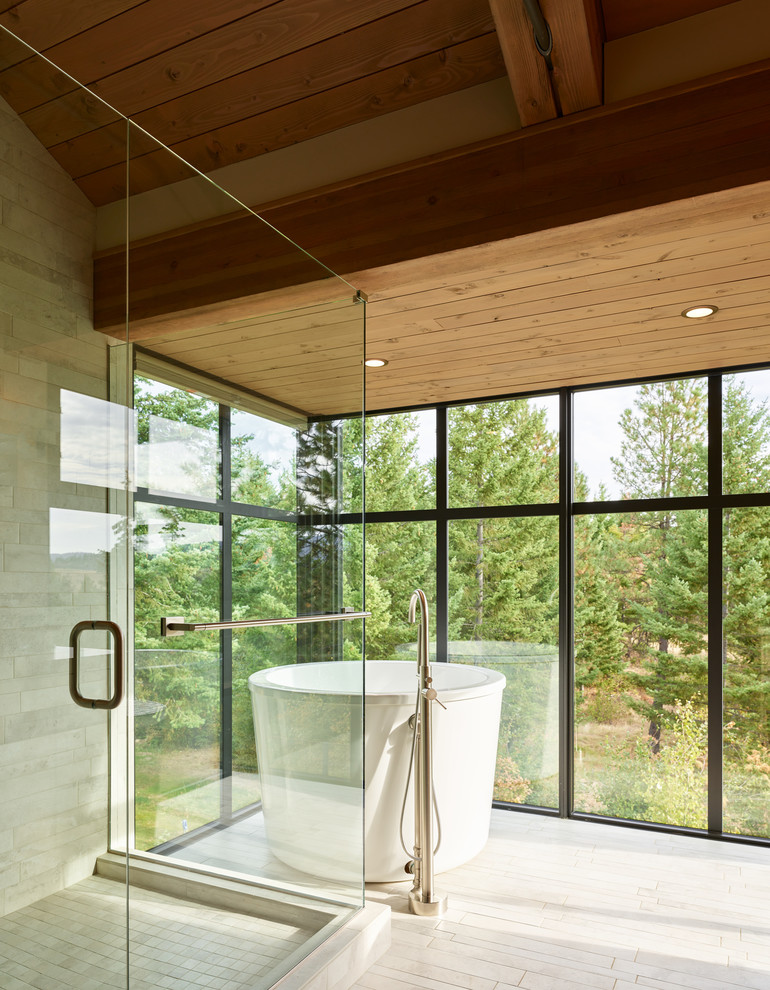 シアトルにあるコンテンポラリースタイルのおしゃれな浴室 (置き型浴槽、コーナー設置型シャワー、ベージュのタイル、グレーの床、開き戸のシャワー) の写真