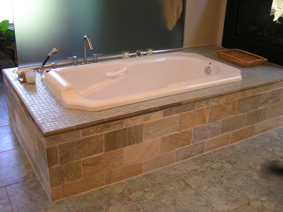 Imagen de cuarto de baño principal rural grande con bañera encastrada, baldosas y/o azulejos beige, baldosas y/o azulejos de piedra, paredes beige y suelo de baldosas de porcelana