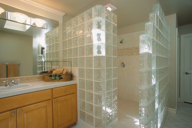 Mid-sized minimalist master beige tile and glass tile ceramic tile doorless shower photo in Dallas with raised-panel cabinets, medium tone wood cabinets, beige walls and a drop-in sink