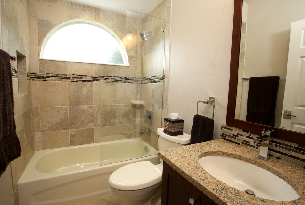 Cette image montre une petite salle d'eau traditionnelle en bois foncé avec un lavabo encastré, une baignoire en alcôve, un combiné douche/baignoire, WC séparés, un carrelage beige, un carrelage marron, un carrelage gris, un carrelage vert, un carrelage multicolore, un mur beige, un placard à porte shaker, un carrelage de pierre, un sol en travertin, un plan de toilette en granite, un sol beige et une cabine de douche à porte coulissante.