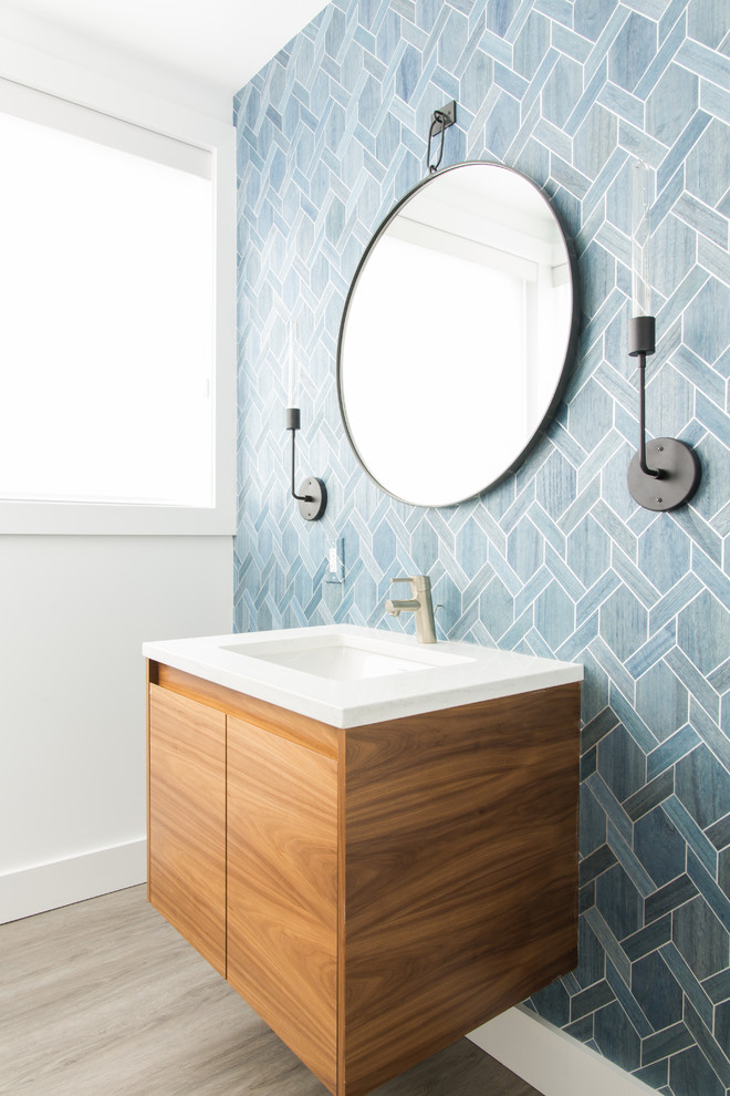 Modernes Badezimmer mit flächenbündigen Schrankfronten, hellbraunen Holzschränken, blauen Fliesen, weißer Wandfarbe, Unterbauwaschbecken, grauem Boden und weißer Waschtischplatte in Philadelphia