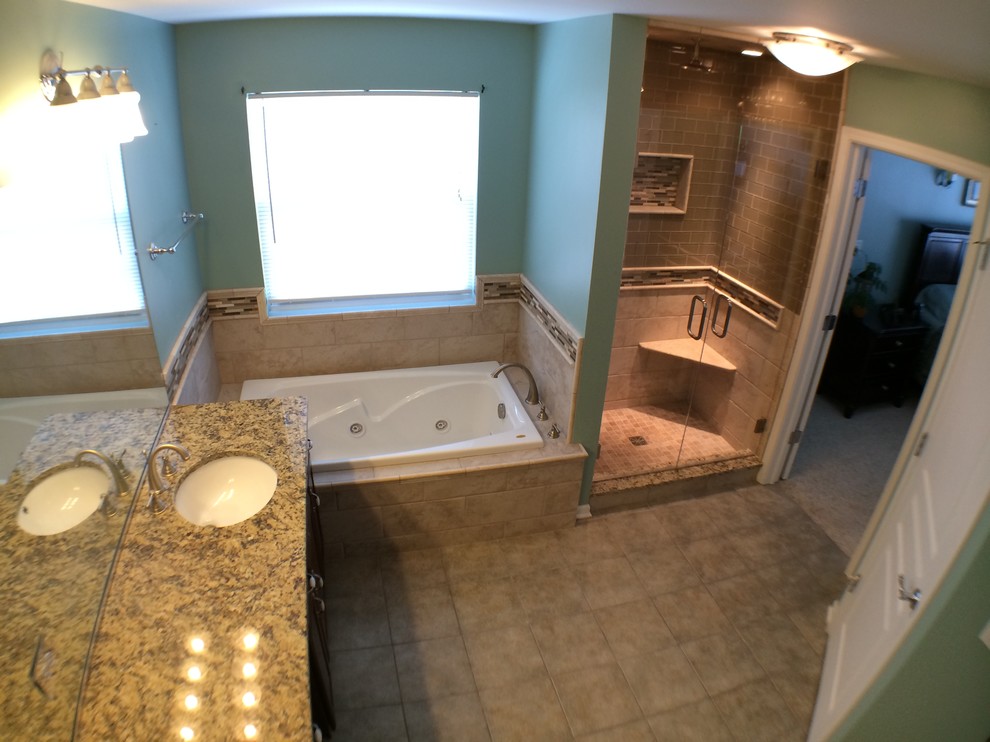 Esempio di una stanza da bagno padronale classica di medie dimensioni con lavabo sottopiano, top in granito, vasca idromassaggio e piastrelle di vetro