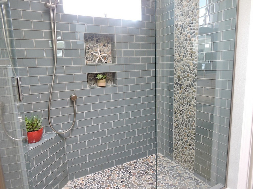 Klassisk inredning av ett badrum, med en dusch i en alkov, grå kakel, tunnelbanekakel och klinkergolv i småsten