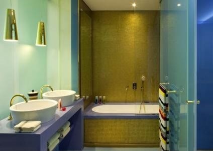 Ejemplo de cuarto de baño bohemio pequeño con bañera empotrada, baldosas y/o azulejos amarillos, baldosas y/o azulejos en mosaico, paredes multicolor, lavabo sobreencimera y encimera de acrílico