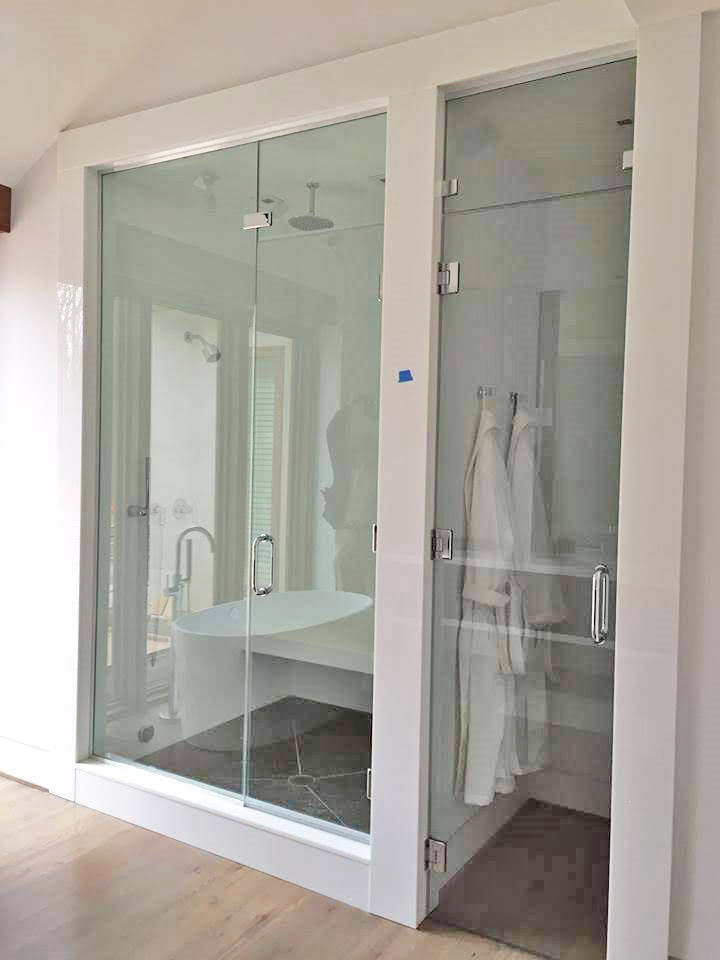 Immagine di una stanza da bagno padronale moderna con ante di vetro, ante bianche, piastrelle bianche, lastra di vetro, top in vetro, porta doccia a battente e top bianco