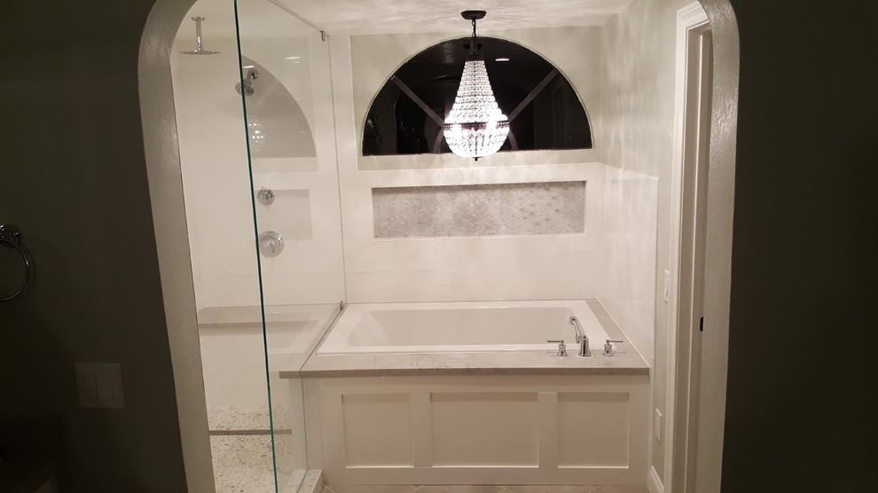 Réalisation d'une salle de bain minimaliste avec un bain bouillonnant, des carreaux de céramique, un sol en carrelage de porcelaine et un sol blanc.
