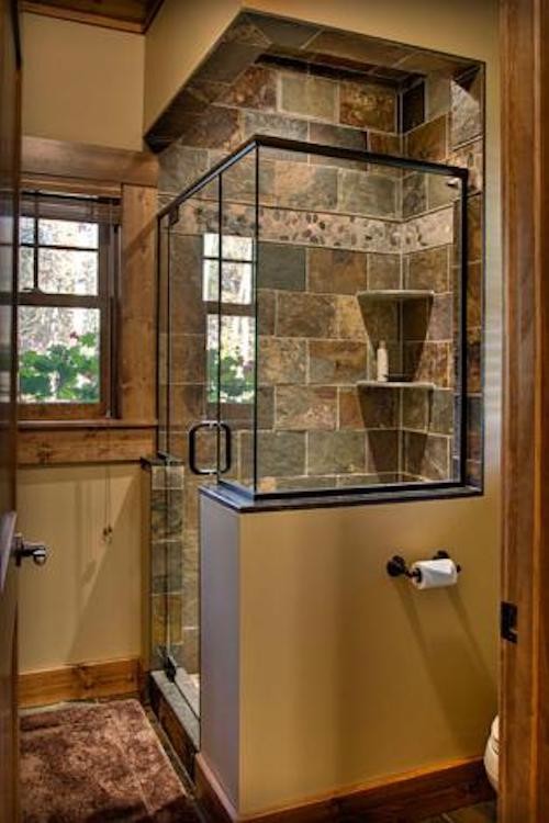 Ejemplo de cuarto de baño rural con ducha esquinera, paredes marrones y ducha con puerta con bisagras