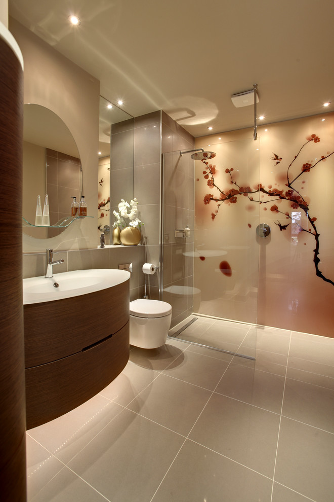 Modelo de cuarto de baño asiático grande con armarios con paneles lisos, puertas de armario de madera oscura, sanitario de pared, paredes grises, suelo gris, ducha abierta, ducha empotrada, baldosas y/o azulejos grises, aseo y ducha, lavabo integrado y encimeras blancas