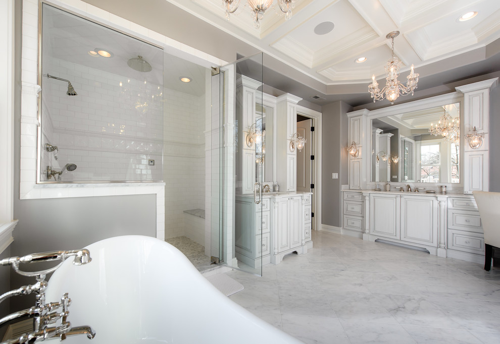 Esempio di una stanza da bagno chic con ante con bugna sagomata, ante bianche, vasca freestanding, pareti grigie e lavabo sottopiano