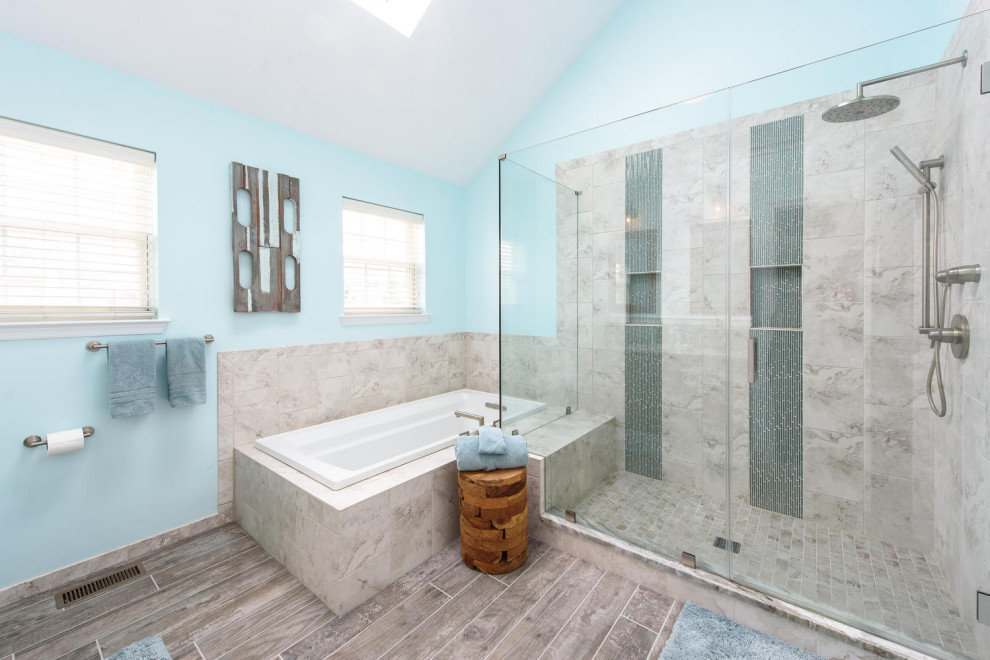 Exemple d'une salle de bain principale moderne de taille moyenne avec un placard à porte affleurante, des portes de placard marrons, une baignoire posée, une douche d'angle, WC séparés, un carrelage bleu, un carrelage en pâte de verre, un mur bleu, un sol en carrelage de porcelaine, un lavabo encastré, un plan de toilette en quartz modifié, un sol beige, une cabine de douche à porte battante et un plan de toilette beige.