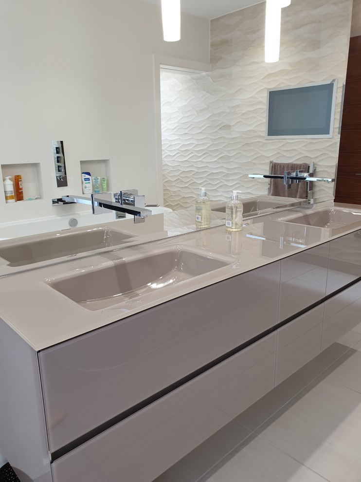 Immagine di una grande stanza da bagno padronale minimalista con ante lisce, ante marroni, piastrelle beige, piastrelle in gres porcellanato, lavabo integrato, top in vetro e top marrone