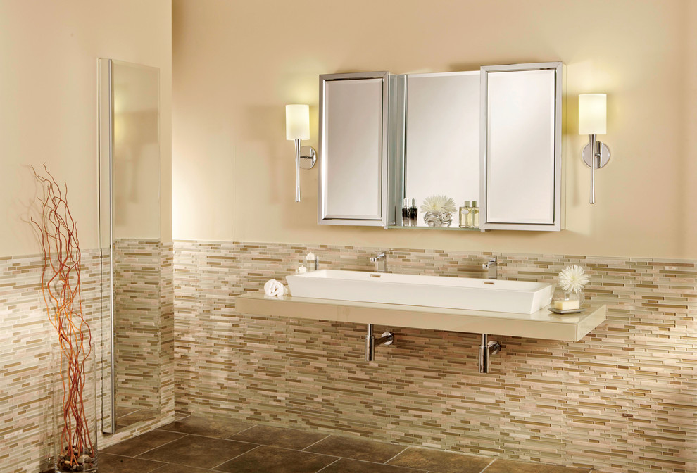 На фото: огромная главная ванная комната в стиле неоклассика (современная классика) с раковиной с несколькими смесителями, стеклянными фасадами, стеклянной столешницей, разноцветной плиткой, стеклянной плиткой, бежевыми стенами и полом из керамической плитки