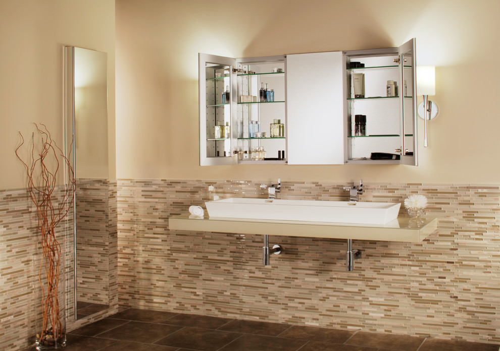 На фото: большая главная ванная комната в стиле неоклассика (современная классика) с раковиной с несколькими смесителями, стеклянной столешницей, разноцветной плиткой, стеклянной плиткой, бежевыми стенами и полом из керамической плитки с