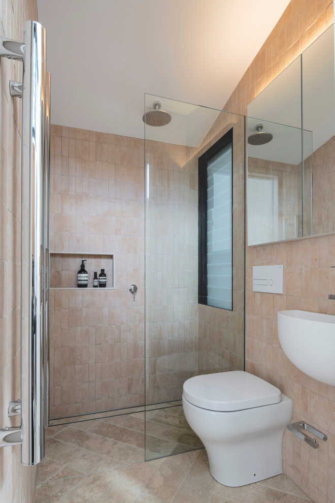 Modelo de cuarto de baño único actual pequeño con ducha empotrada, paredes beige, aseo y ducha, lavabo suspendido, suelo beige, ducha abierta y hornacina