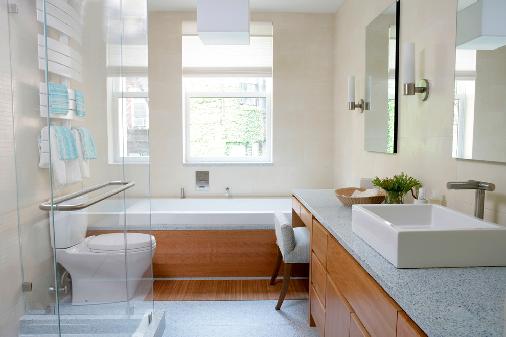 Modern inredning av ett mellanstort badrum med dusch, med släta luckor, skåp i mellenmörkt trä, ett badkar i en alkov, en dusch i en alkov, en toalettstol med separat cisternkåpa, beige kakel, beige väggar och ett fristående handfat