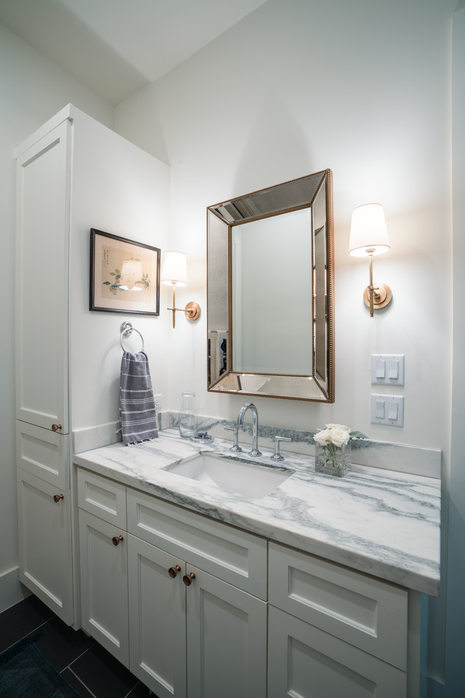 Cette image montre une salle de bain rustique avec un placard à porte shaker et un plan de toilette en marbre.