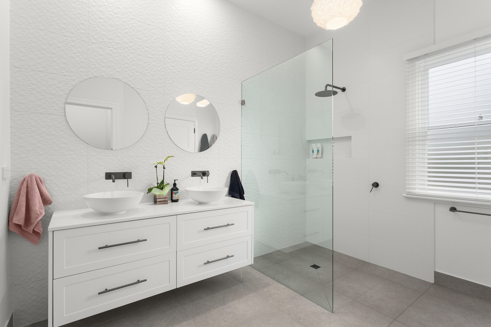 Medium sized contemporary family bathroom in Melbourne with shaker cabinets, white cabinets, a walk-in shower, white tiles, ceramic tiles, white walls, ceramic flooring, engineered stone worktops, grey floors, an open shower, white worktops, a wall niche, double sinks and a floating vanity unit.