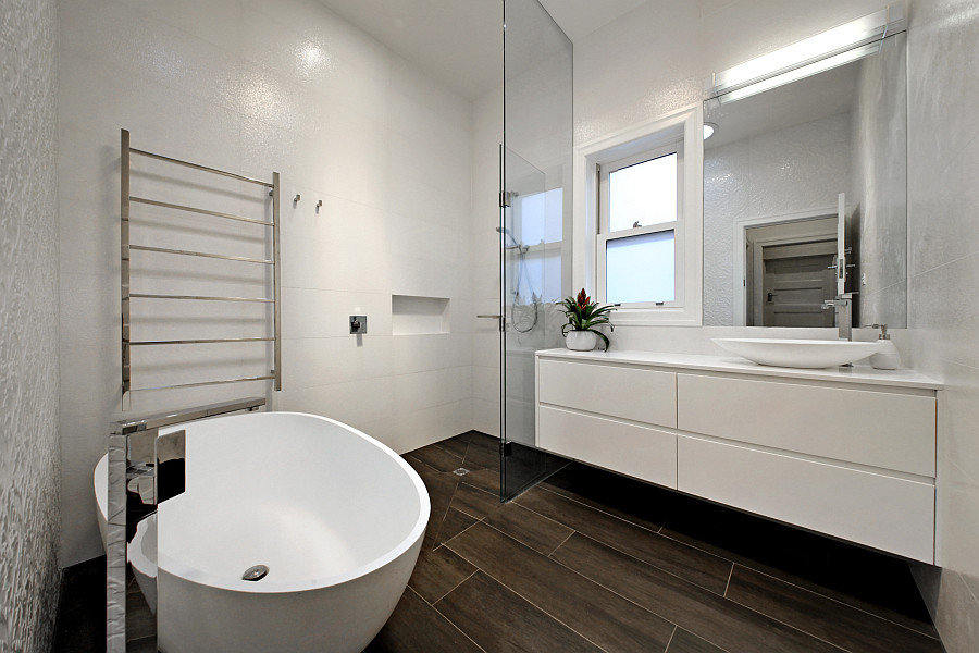 Großes Modernes Duschbad mit weißen Schränken, freistehender Badewanne, offener Dusche, weißen Fliesen, Porzellanfliesen, weißer Wandfarbe, Porzellan-Bodenfliesen, Quarzwerkstein-Waschtisch, flächenbündigen Schrankfronten und Aufsatzwaschbecken in Melbourne