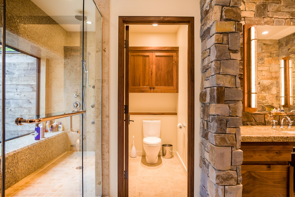 Foto di una stanza da bagno padronale stile rurale di medie dimensioni con ante lisce, ante in legno chiaro, doccia alcova, piastrelle in pietra, lavabo sottopiano, top in granito e porta doccia a battente