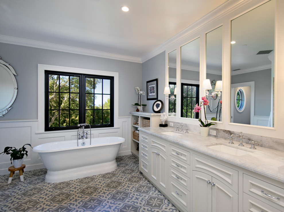 Example of a classic multicolored floor, double-sink and wainscoting freestanding bathtub design in Santa Barbara with recessed-panel cabinets, white cabinets, gray walls, an undermount sink, gray countertops and a built-in vanity