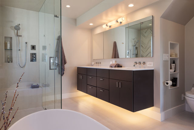 Inspiration for a modern ensuite bathroom in San Francisco with a submerged sink, flat-panel cabinets, dark wood cabinets, solid surface worktops, a freestanding bath, a built-in shower, a wall mounted toilet, white tiles, porcelain tiles, grey walls and porcelain flooring.