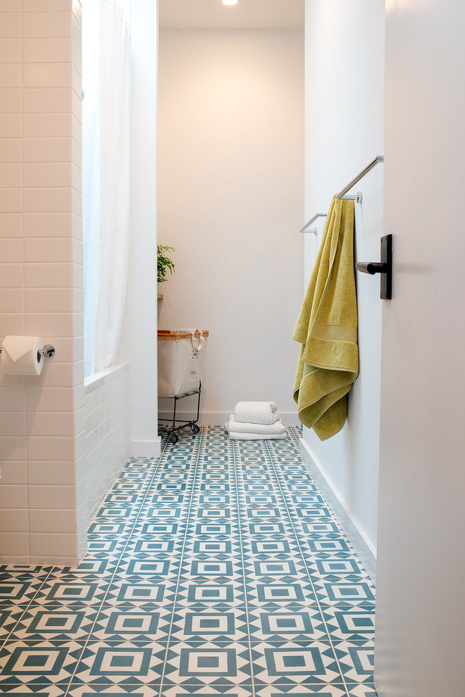 Foto på ett mellanstort funkis badrum, med ett platsbyggt badkar, en dusch/badkar-kombination, en vägghängd toalettstol, blå kakel, keramikplattor, vita väggar, klinkergolv i keramik, ett nedsänkt handfat, bänkskiva i kvarts, flerfärgat golv, dusch med duschdraperi, släta luckor och skåp i mörkt trä