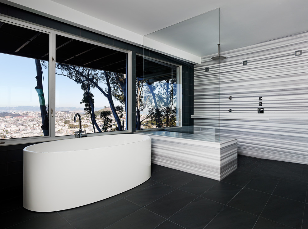 Ejemplo de cuarto de baño minimalista con ducha a ras de suelo, bañera exenta, suelo negro y ventanas