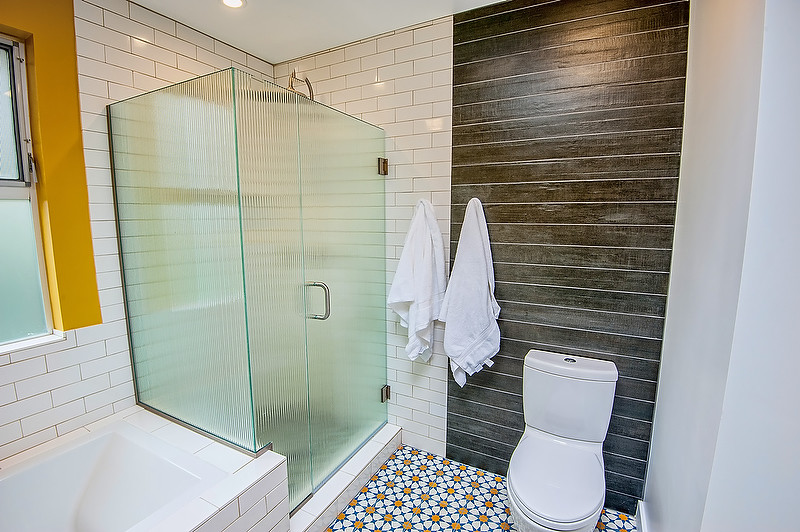 Inspiration for a mid-sized 1960s 3/4 white tile and stone tile cement tile floor and blue floor corner shower remodel in Los Angeles with open cabinets, an undermount tub, a two-piece toilet, yellow walls, a trough sink, solid surface countertops and a hinged shower door