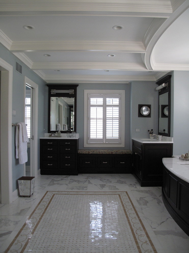 Imagen de cuarto de baño principal actual grande con puertas de armario negras, paredes azules, suelo de mármol y suelo gris