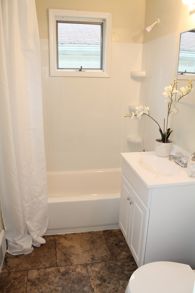Idee per una piccola stanza da bagno classica con ante con bugna sagomata, ante bianche, vasca ad alcova, vasca/doccia, pareti bianche, pavimento in vinile e top in superficie solida