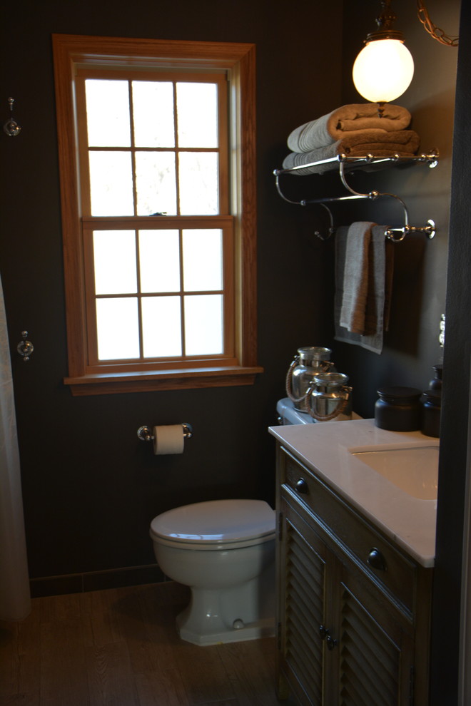 ミルウォーキーにあるお手頃価格の小さなラスティックスタイルのおしゃれな浴室 (ヴィンテージ仕上げキャビネット、珪岩の洗面台、置き型浴槽、茶色いタイル、セラミックタイル、グレーの壁、セラミックタイルの床) の写真
