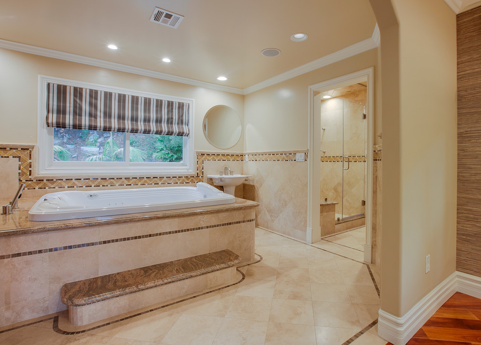 Immagine di una grande stanza da bagno padronale minimal con vasca idromassaggio, doccia alcova, piastrelle beige, piastrelle in pietra, pareti beige, pavimento in pietra calcarea, lavabo a colonna e top in granito