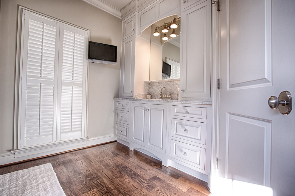 Idéer för att renovera ett mellanstort vintage en-suite badrum, med ett undermonterad handfat, luckor med profilerade fronter, vita skåp, marmorbänkskiva, ett fristående badkar, vit kakel, porslinskakel och mellanmörkt trägolv