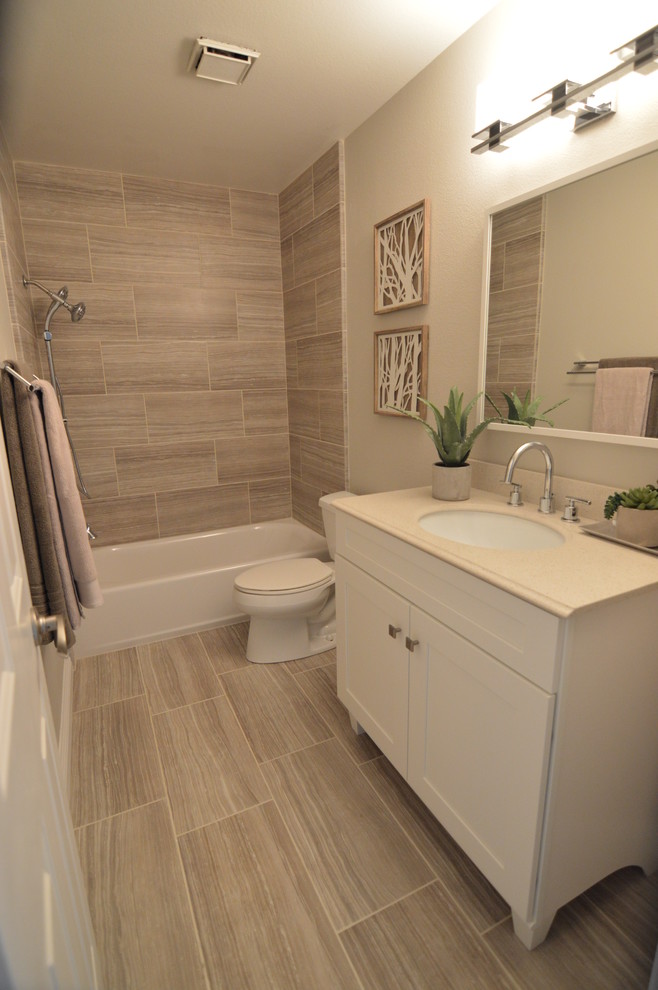 На фото: ванная комната среднего размера: освещение в современном стиле с фасадами в стиле шейкер, белыми фасадами, душем над ванной, раздельным унитазом, бежевыми стенами, душевой кабиной, врезной раковиной и столешницей из искусственного камня с