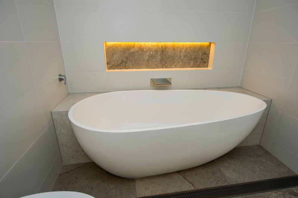 Mittelgroßes Modernes Badezimmer mit Aufsatzwaschbecken, beigen Schränken, freistehender Badewanne, offener Dusche, Wandtoilette, beiger Wandfarbe und Porzellan-Bodenfliesen in Melbourne