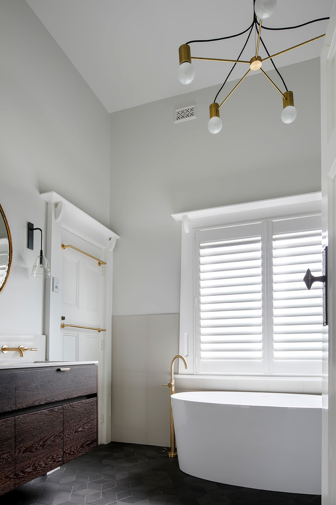 Idée de décoration pour une salle de bain principale design en bois foncé avec un placard en trompe-l'oeil, une baignoire indépendante, une douche ouverte, un carrelage multicolore, des carreaux de béton et un mur gris.