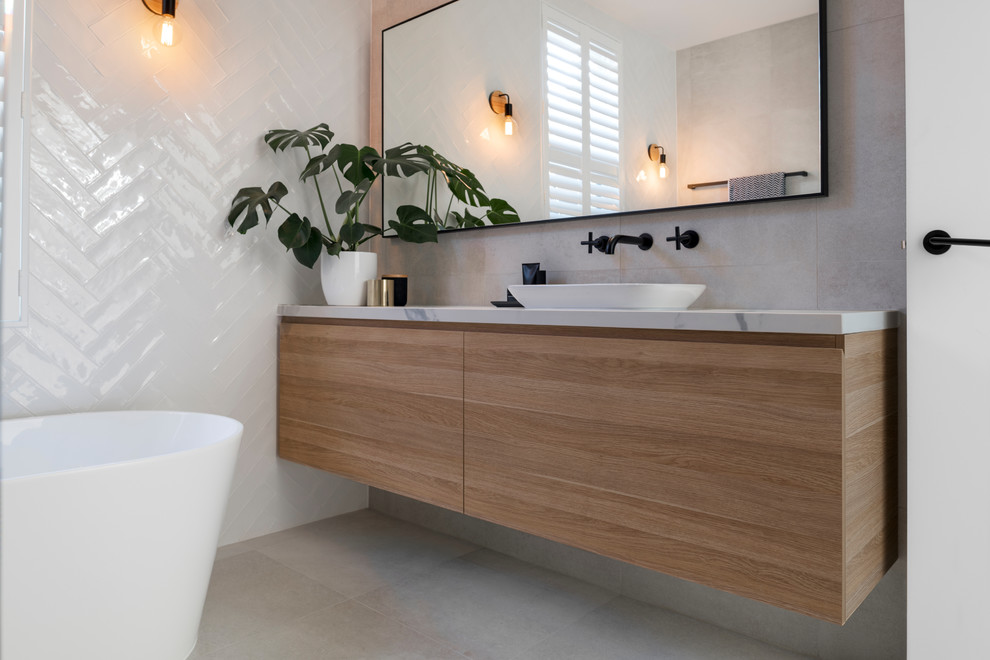 Idéer för att renovera ett mellanstort skandinaviskt grå grått badrum, med ett fristående badkar, en öppen dusch, en vägghängd toalettstol, vit kakel, keramikplattor, vita väggar, klinkergolv i keramik, ett konsol handfat, bänkskiva i kvarts, grått golv och med dusch som är öppen