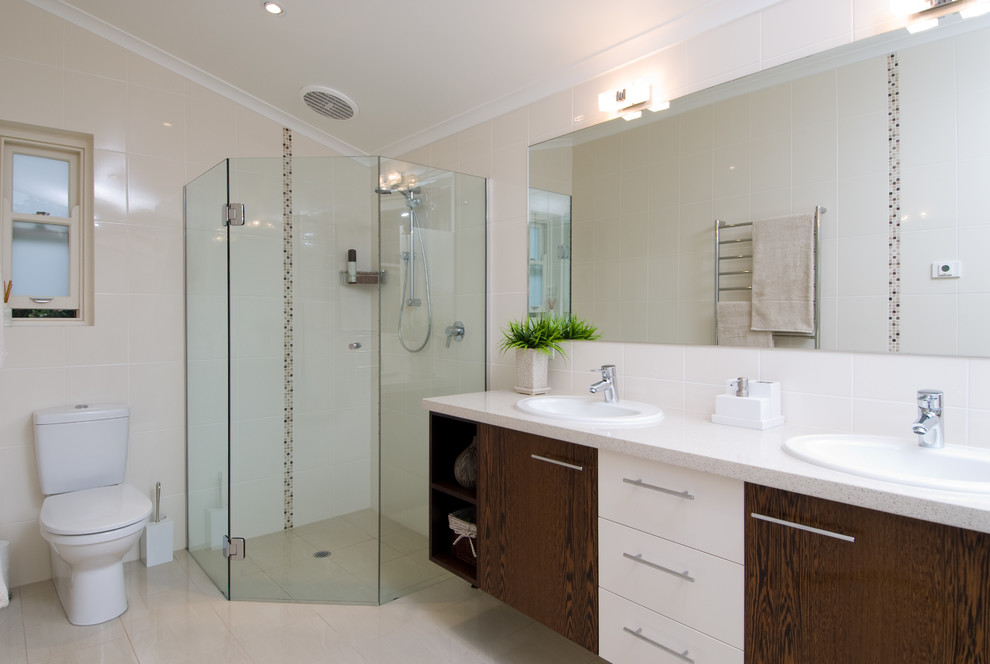 Idee per una stanza da bagno con doccia design di medie dimensioni con lavabo da incasso, ante in legno bruno, doccia ad angolo, WC a due pezzi, piastrelle beige e pareti beige