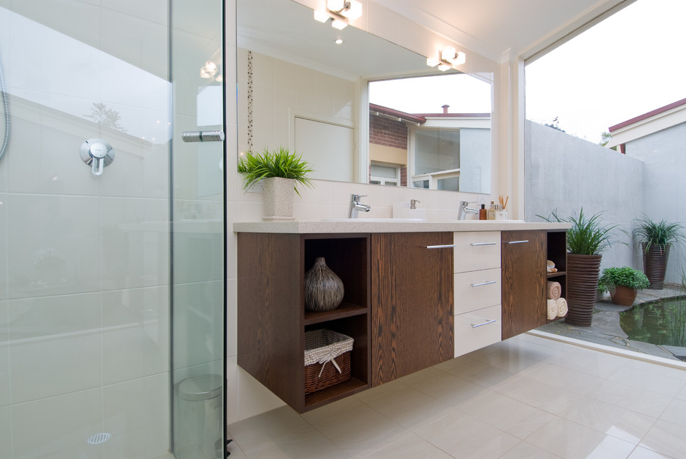 Immagine di una stanza da bagno con doccia design di medie dimensioni con lavabo da incasso, ante in legno bruno, doccia ad angolo, WC a due pezzi, piastrelle beige e pareti beige